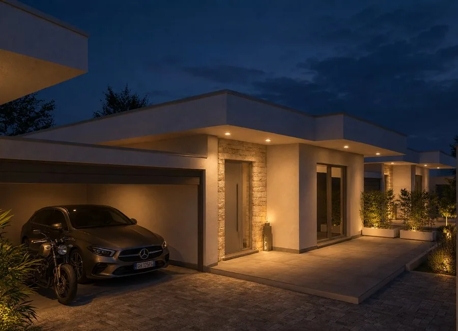 Vista serale dell’ingresso della villa con box doppio e illuminazione calda