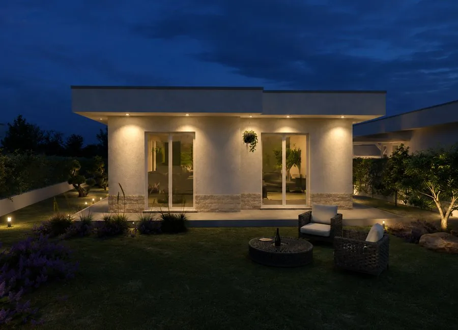 Vista frontale serale della villa con giardino illuminato