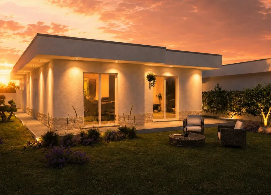 Vista del giardino al tramonto con arredo outdoor e grandi vetrate